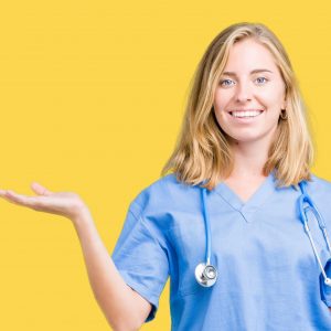 Beautiful young doctor woman wearing medical uniform over isolated background smiling cheerful presenting and pointing with palm of hand looking at the camera