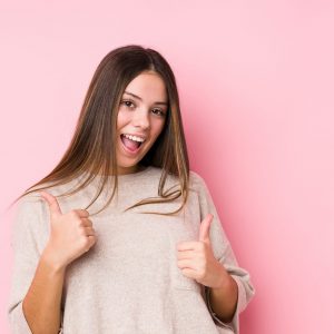 young-caucasian-woman-posing-isolated-raising-both-thumbs-up-smiling-and-confident-1-scaled-e1610983095331